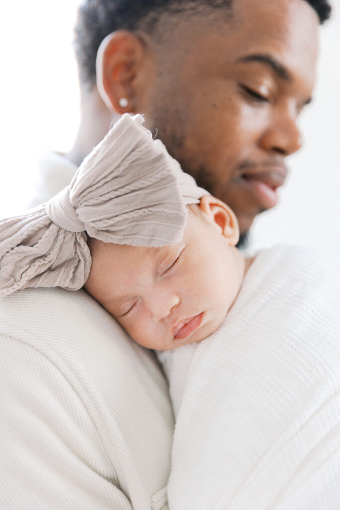 newborn sleeping on dad's shoulder