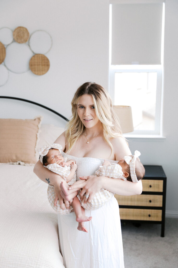 Mom standing while holding her twin baby girls