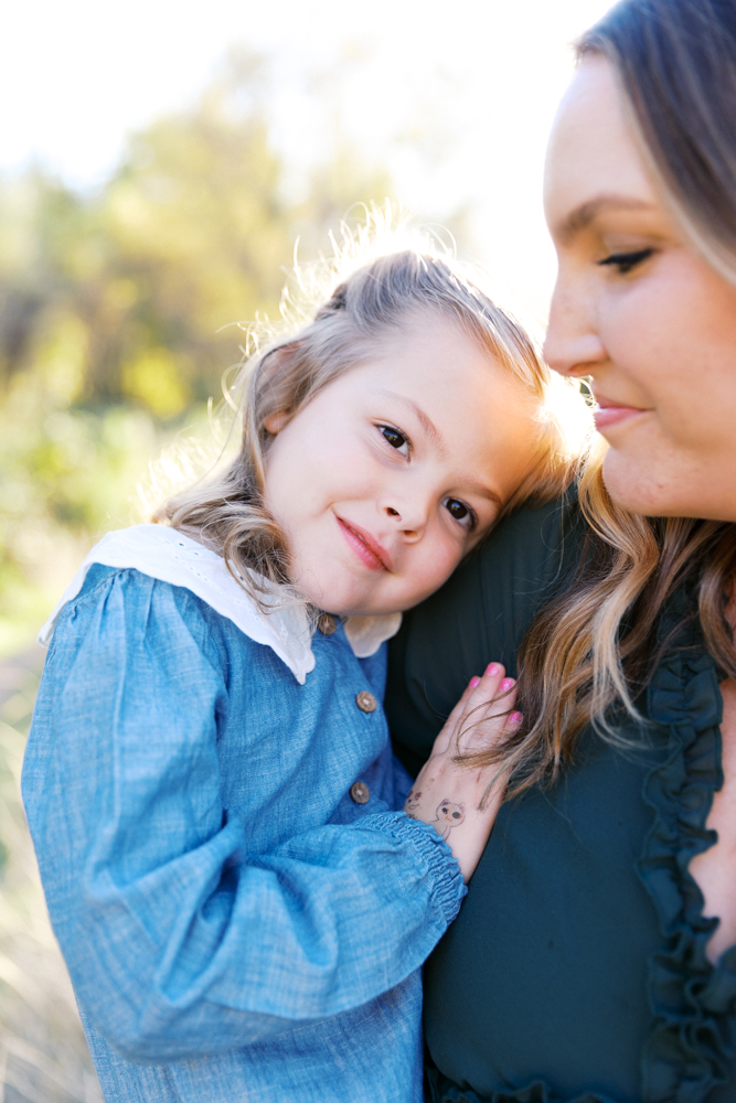 daughter laying head on mom's shoulder