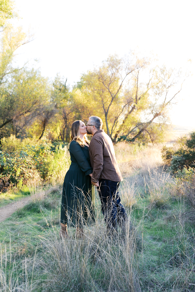 mom and dad kissing in tall grass